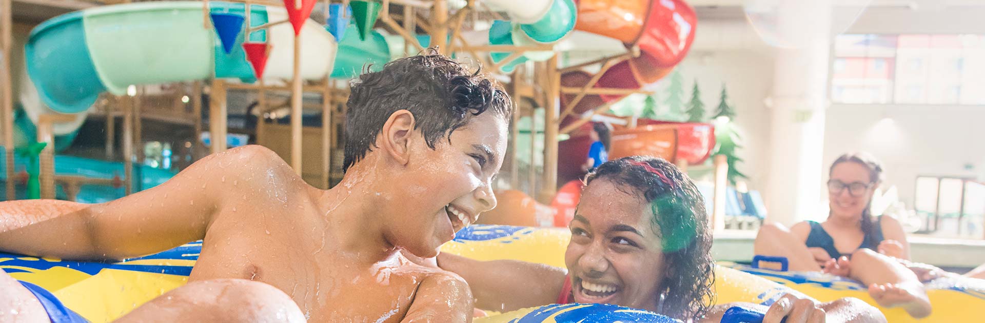 two teenagers share a tube down the lazy river